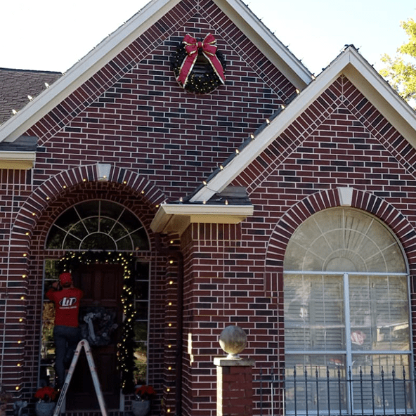 House decorated with Christmas lights and wreath.